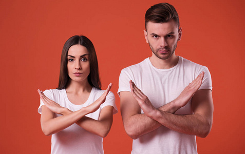 男人显示停止标志严肃的男人和女人在镜头上显示不同意的标志或手势
