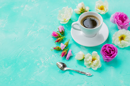 早晨一杯咖啡和美丽的玫瑰花在浅色背景, 顶视图。舒适的早餐。平面布局风格。平坦的家居空间背景。舒适的早餐