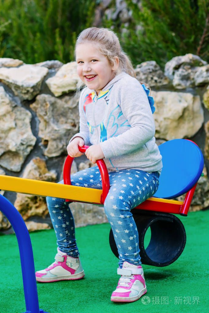 在公园的操场上荡秋千的孩子