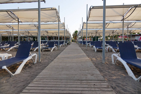 海滩上配有雨伞的太阳椅。旅游业