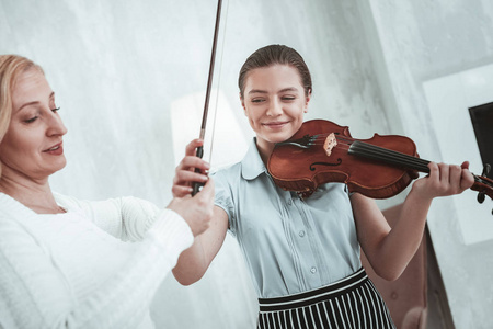 高兴的快乐女孩拿小提琴弓