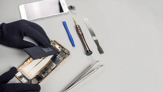 技师或工程师拆卸损坏的智能手机部件，取出电池进行修理，或用复制间隔更换新的智能手机电池