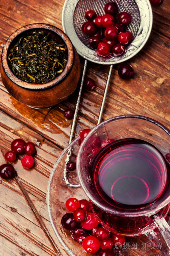 木桌上杯子里的蔓越莓茶