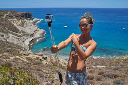 夏季地中海沿岸带Gopro摄像机的年轻女子