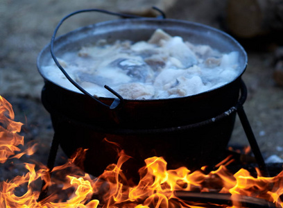 在营地准备食物热的食物在大火的大锅里沸腾