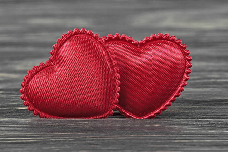 情人节的概念。 两颗红色的心在黑暗的木制背景上。