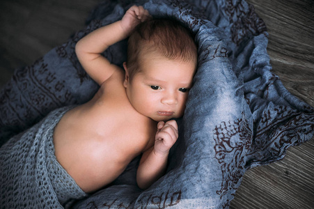 特写躺在蓝布上的男婴肖像