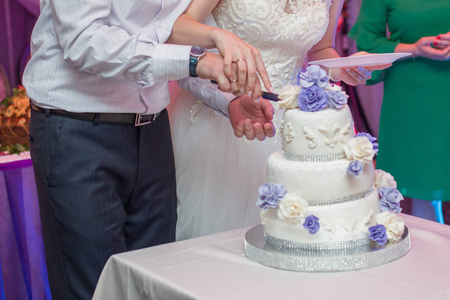 新郎新娘用刀把婚礼蛋糕切碎