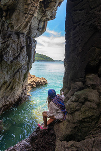 旅游人员女游客在一个靠近大海的洞穴里，在科西昌度假和度假旅游泰国。 旅行夏季概念