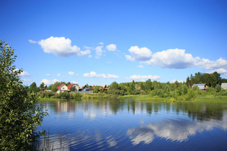 湖反射天空与云彩在它流经一个小村庄