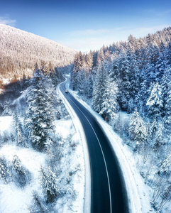 冬季道路和森林的鸟瞰图。 来自空气的自然冬季景观。 雪下的森林是冬天的时候。 无人机景观