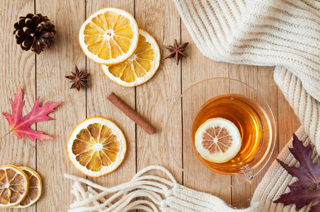 一杯柠檬茶，放在木桌上，配上针织围巾和装饰