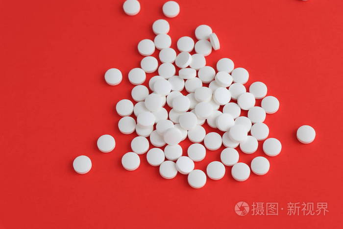 平板电脑药为人的健康愈合疾病, 在白色表面溢出的白色药丸的顶视图