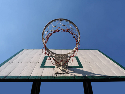 仰望蓝天背景下的篮球圈。
