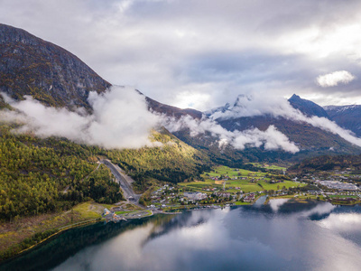 无人驾驶飞机照片的里昂在挪威的城市景观与Innvikfjorden峡湾在前景和云层覆盖大山的背景概念的旅行和和谐。