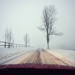 冬天开车。 从一辆汽车的内部观看雪道上的司机的眼睛。 冬季驾驶安全的概念。