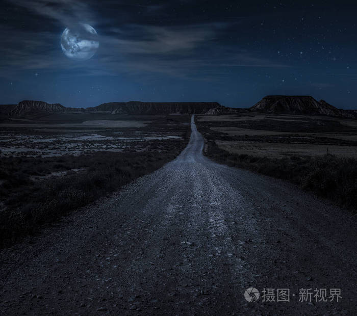 夜晚的月亮星星和云彩. 狂野的西路从月亮上照亮. 月光和道路背景.