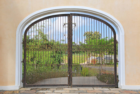 水泥围栏铁门在水泥墙上通向花园.照片