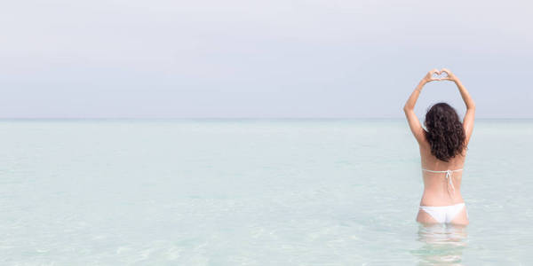 美丽的女人在热带海滩上放松。 横向横幅尺寸复制照片