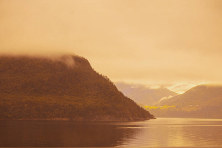 傍晚美丽的山海景观。 日落时的峡湾。 挪威的野性。 海景