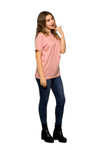 一个穿着粉红色毛衣的青少年女孩做电话手势的完整镜头。 给我回个电话，在白色背景下