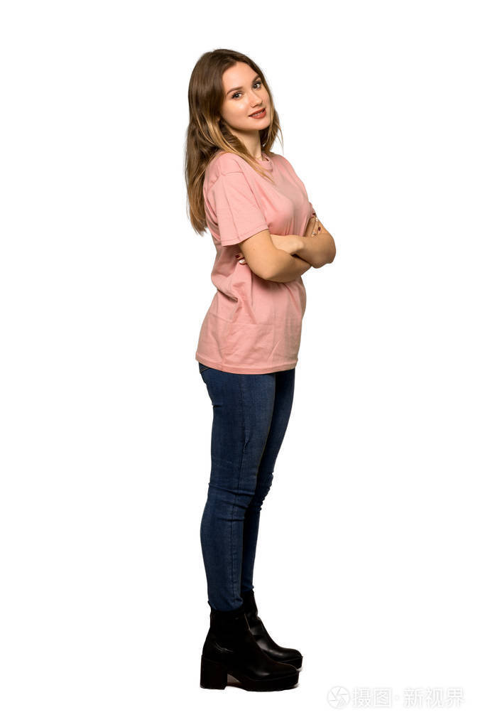 一个穿着粉红色毛衣的少年女孩,双臂交叉,在孤立的白色背景下向前看