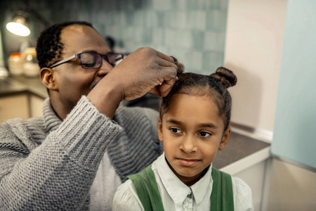 为小女儿做发型的非洲裔美国父亲