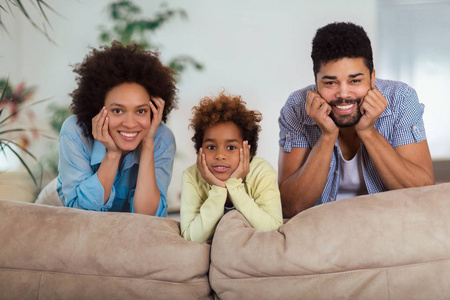幸福的家庭一起在沙发上摆姿势，在客厅里选择性地聚焦。