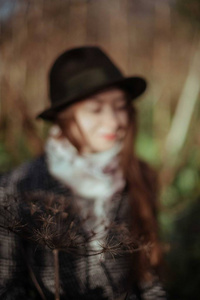 晴天戴帽子的年轻女子的肖像。一个戴帽子的漂亮女孩在田野里的特写镜头