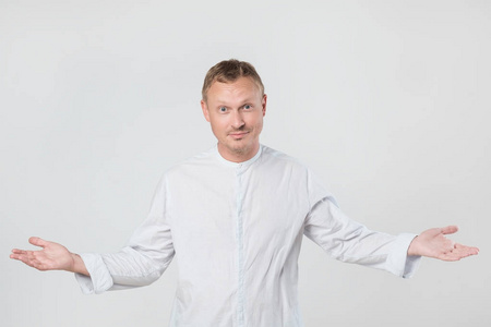 随意的年轻人张开双臂欢迎你,带着安慰的微笑. 我很高兴见到你.照片