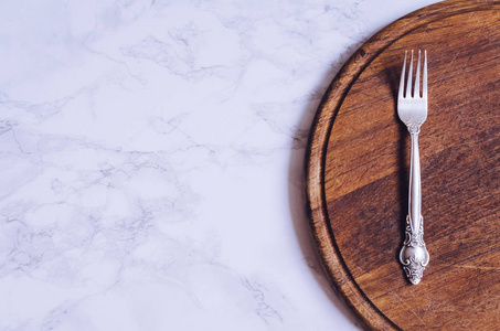 大理石桌子上的叉子和木板，有文字的地方。 食物背景。 菜单概念。 上面的风景。 复制空间。
