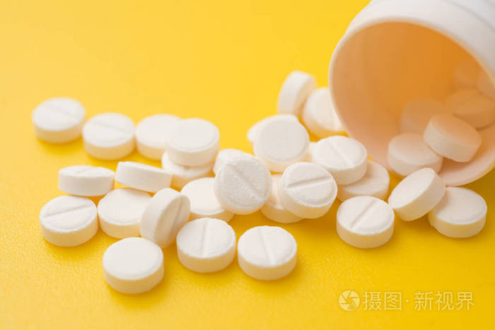 白色药片阿司匹林黄色背景止痛药概念