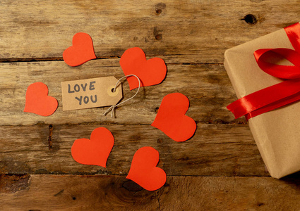 礼物红色的心和爱你的信息，木制的复古背景风格，在情人节装饰，结婚纪念日庆祝，母亲和父亲日贺卡和爱的概念。