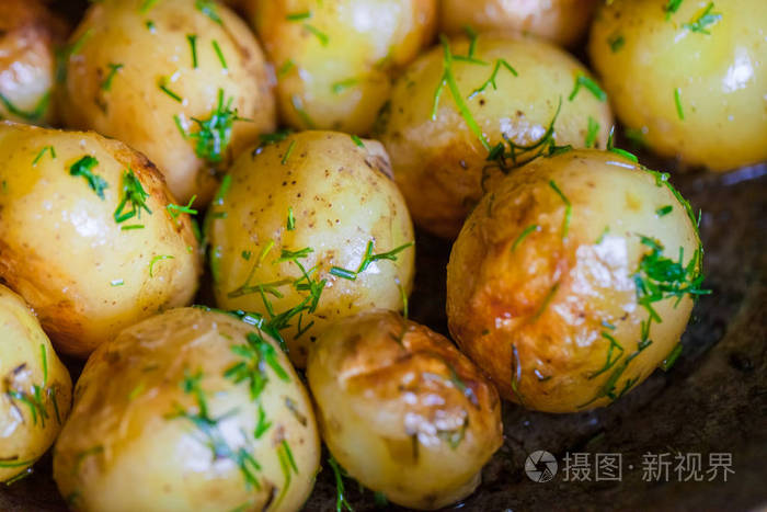 烤土豆夹克土豆整个他们的皮肤与向日葵油和刺到金黄色特写