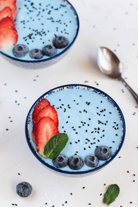 蓝色酸奶冰沙由蓝色螺旋藻粉末草莓和蓝莓制成。