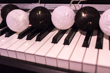 一个五颜六色的气球花环在钢琴上发光。 装饰元素到新年快乐。