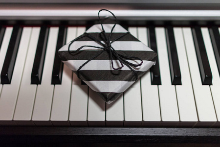 礼品盒在钢琴键盘上的条纹黑白包装。