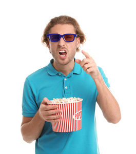 在白色背景电影放映期间，带3D眼镜和爆米花的情绪化男人