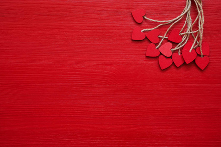 情人节背景。 红色背景上的红色木心。 复制空间顶部视图。 平躺的情人节庆祝概念。
