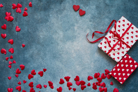 情人节背景。 蓝色背景上的红心和礼品盒。 复制空间顶部视图。 平躺情人节庆祝概念
