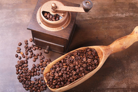 咖啡豆在木铲和咖啡磨床在黑暗的石头桌