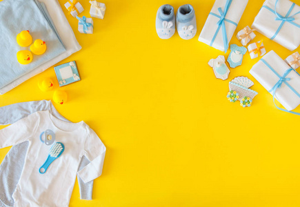 婴儿在黄色背景与服装洗漱用品玩具和保健配件.