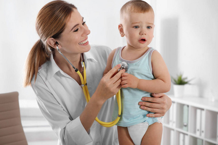 s doctor examining little boy with stethoscope in hospital