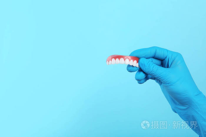 牙医在颜色背景上戴着牙套。 文本空间