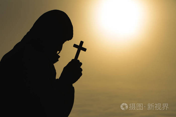 基督教年轻人在日出时用十字架祈祷的剪影,基督教的概念背景.