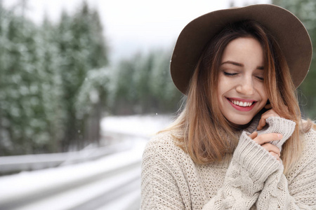 年轻的女人在户外下雪的日子里发短信。 寒假