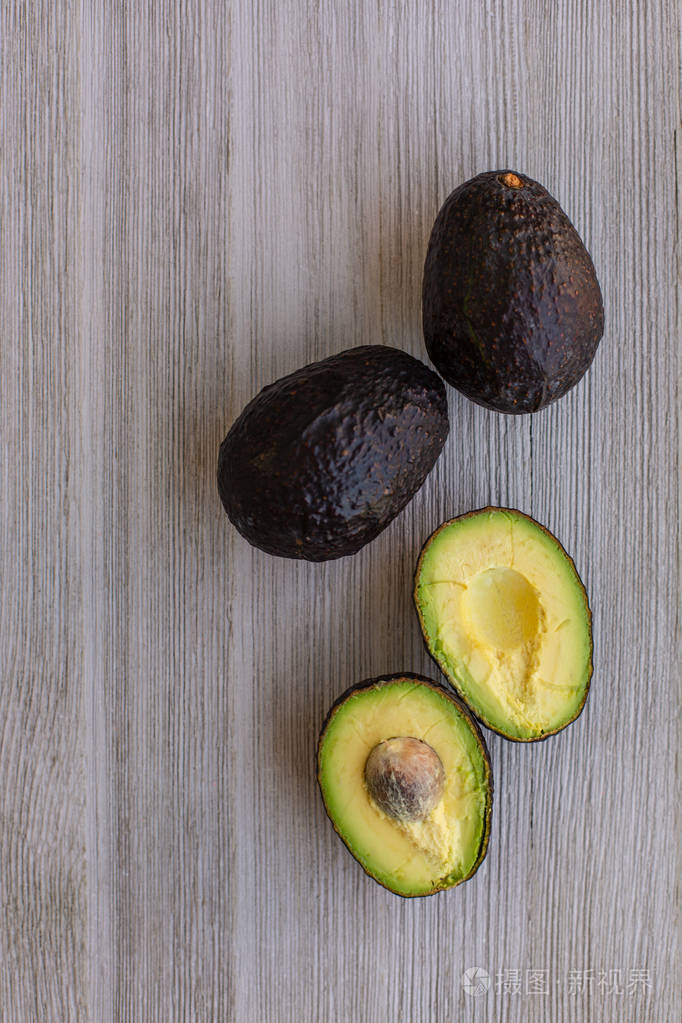 木制桌子上新鲜的生牛油果. 成熟的水果. 健康的食物概念.