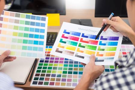 设计师平面创意创意合作着色使用图形平板电脑和手写笔在办公桌与同事