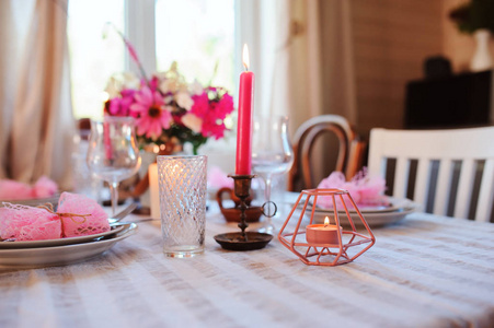 在舒适的乡间别墅里吃浪漫的夏季晚餐。 节日桌上摆着紫色的花和蜡烛