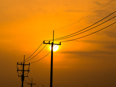 日落时电线杆和电线的轮廓与泰国的云。